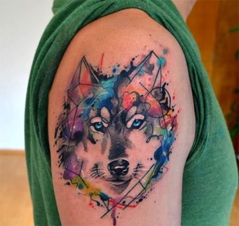 Tatuaggio ad acquerello di un lupo sulla spalla