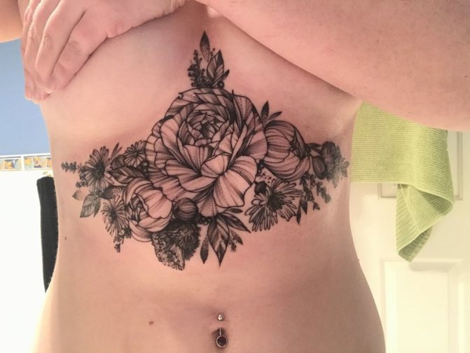 Suuri tatuointi, jossa on ruusu hänen rintojensa alla