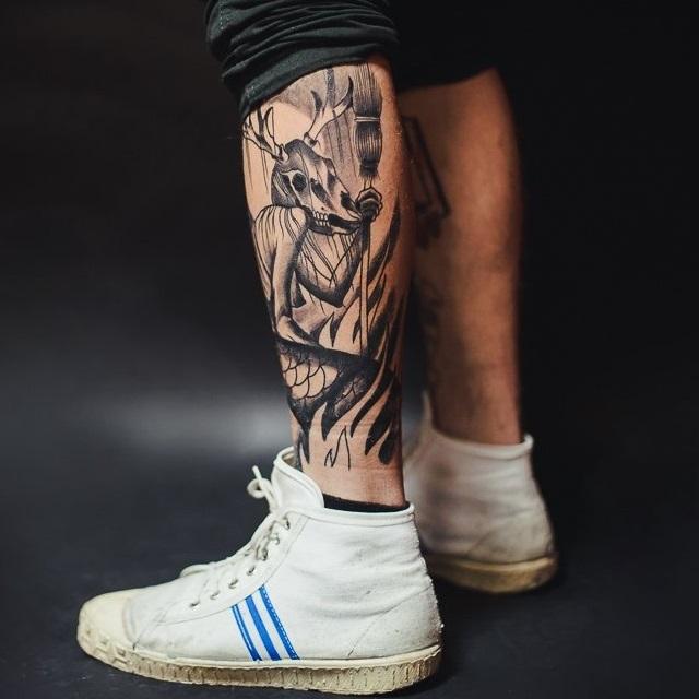 Zwart-witte mannelijke tatoeage op benen