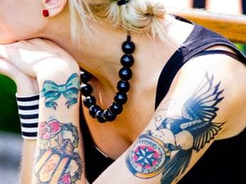 цветна татуировка върху бицепса на жена
