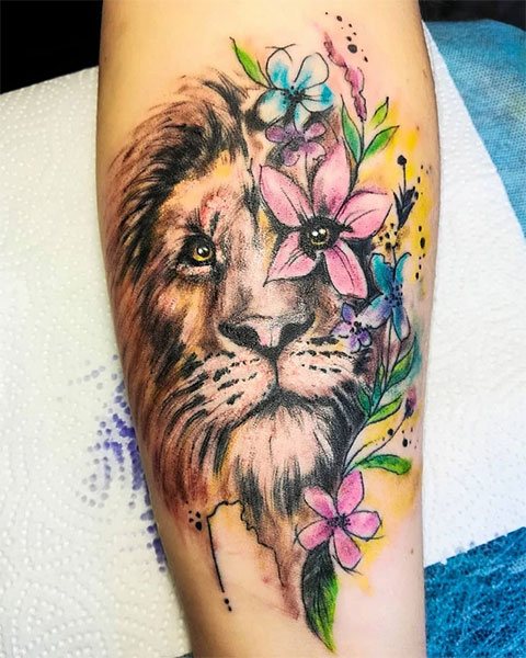 Tatuagem colorida de leão no braço de uma rapariga