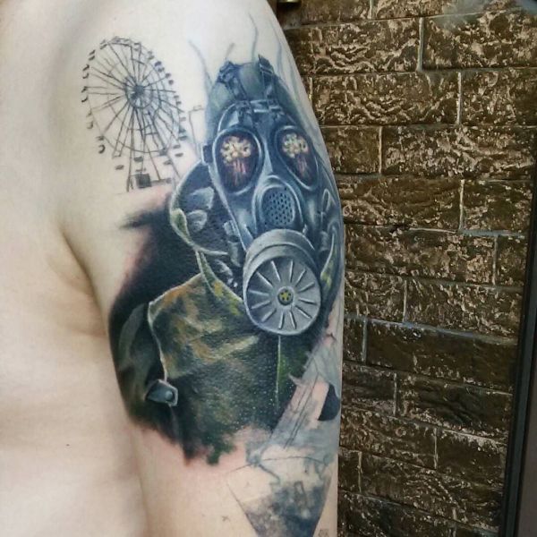 Värillinen tatuointi ahdistelijasta, jolla on kaasunaamari olkapäällään.