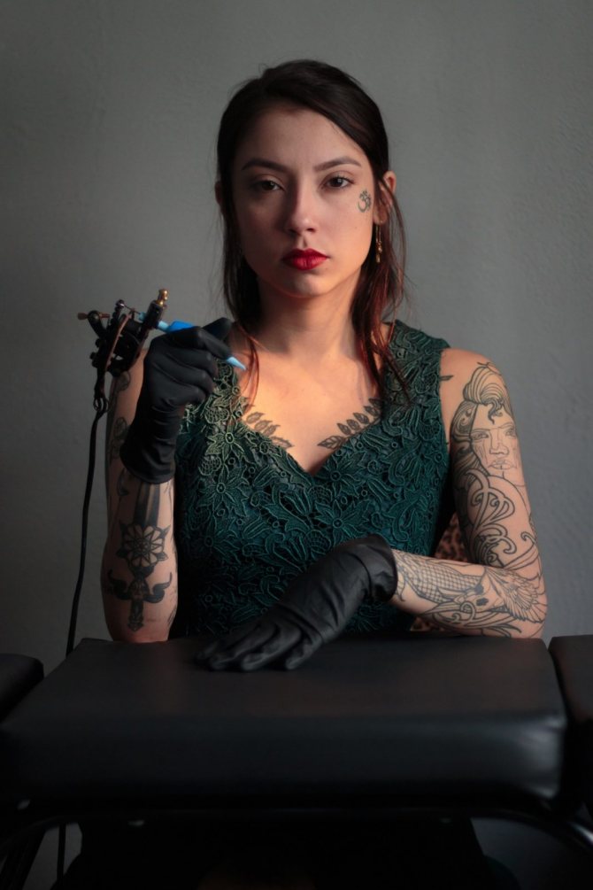 Tyttö, jolla on tatuointikone kädessään