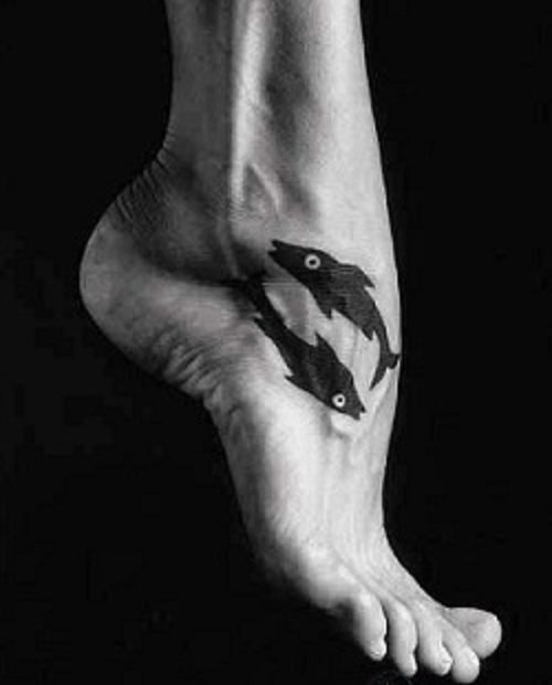 Yin yang žuvis ant pėdos
