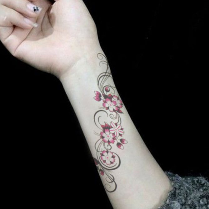 Puiki susipynusi tatuiruotė ant moters dilbio ir riešo