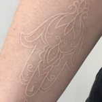 Hvid omrids tatovering på arm