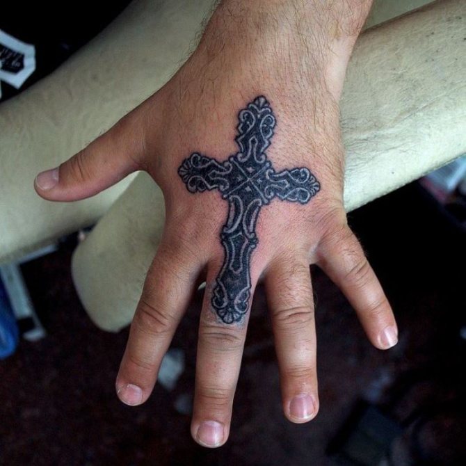 kors på tommelfinger tatovering