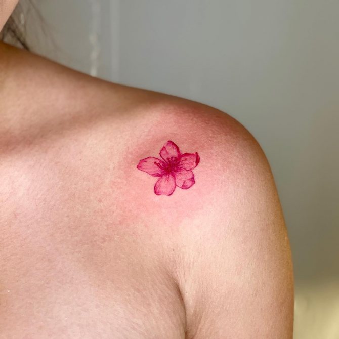 Mini tatovering af kirsebær på hendes skulder
