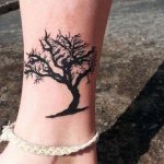 árvore em miniatura na perna de uma menina