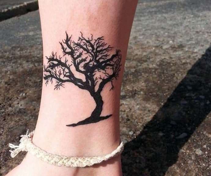Miniatűr fa egy lány lábán