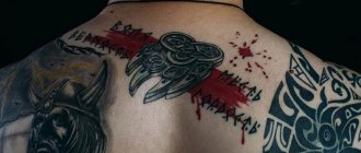 muž so slovanským tetovaním na chrbte
