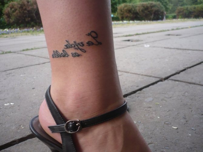 Tatuaggio alla caviglia con uno slogan