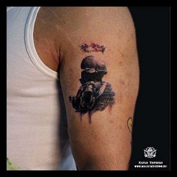 Malé stalkerské tetovanie na ramene chlapa