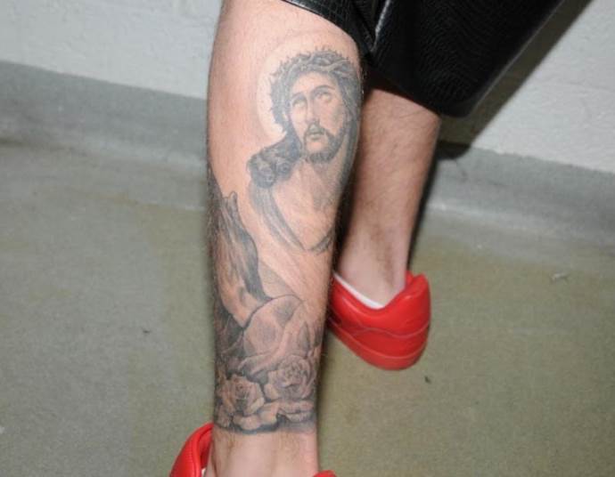 religiøs tatovering på hans ben