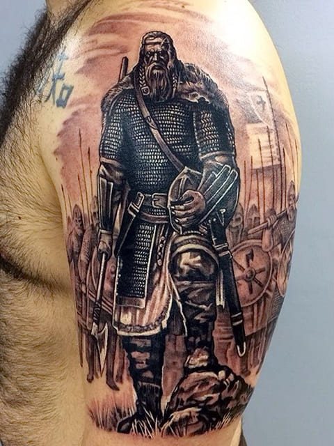 男性の肩に彫られた女神のタトゥー