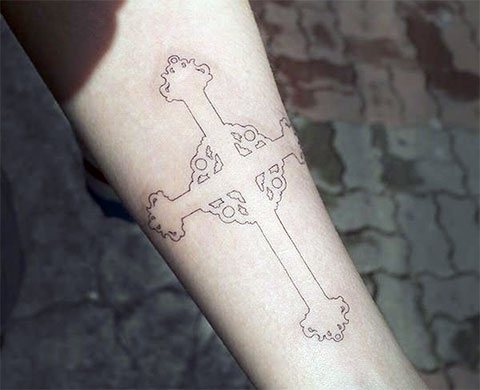 Tattoo sort kors på venstre arm
