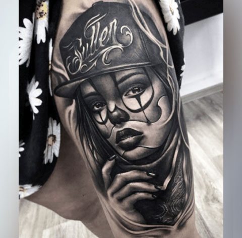 Tatuiruotė Chicano ant mergaitės šlaunies