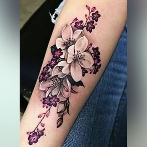 Tatuaggio fiori di ciliegio sulla mano di una ragazza