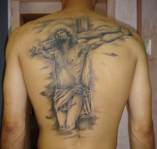 腕、背中、肩、胸にイエスのタトゥー。意味は、十字架の上で、悪魔と、機械と、鳩と