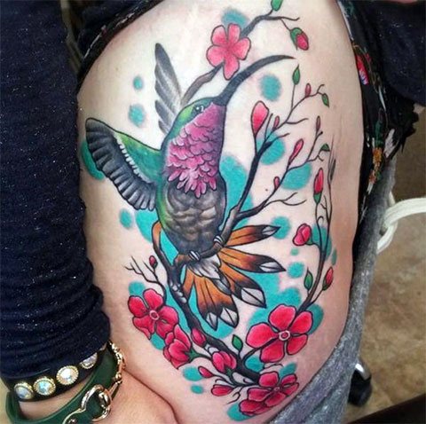Tattoo van een kolibrie op zijn dij