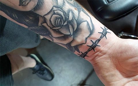 Spygliuota viela ir rožių tatuiruotė