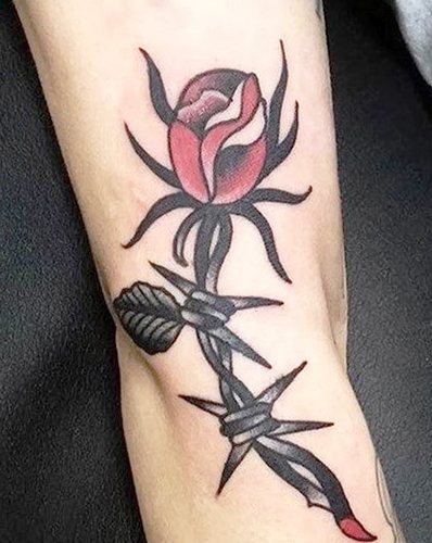 Tatuaggio con filo spinato. Significazione su piede, polso, collo, gamba, con fiori, rosa, cuore, croce