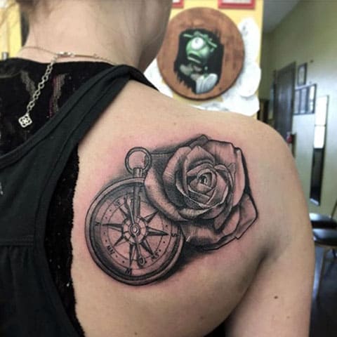 Kompas en roos tattoo op het schouderblad - afbeelding