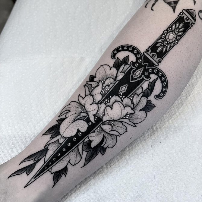 Tatuaggio pugnale corto con fiori sull'avambraccio
