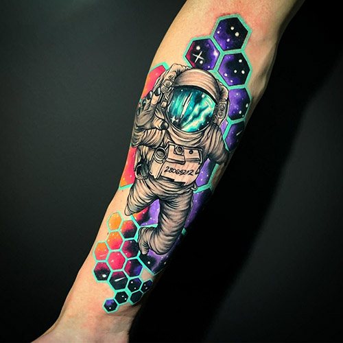 在你的手臂上纹上宇航员。草图、意义、照片