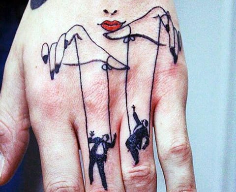 Τατουάζ ενός κουκλοπαίκτη και μαριονέτες στο χέρι