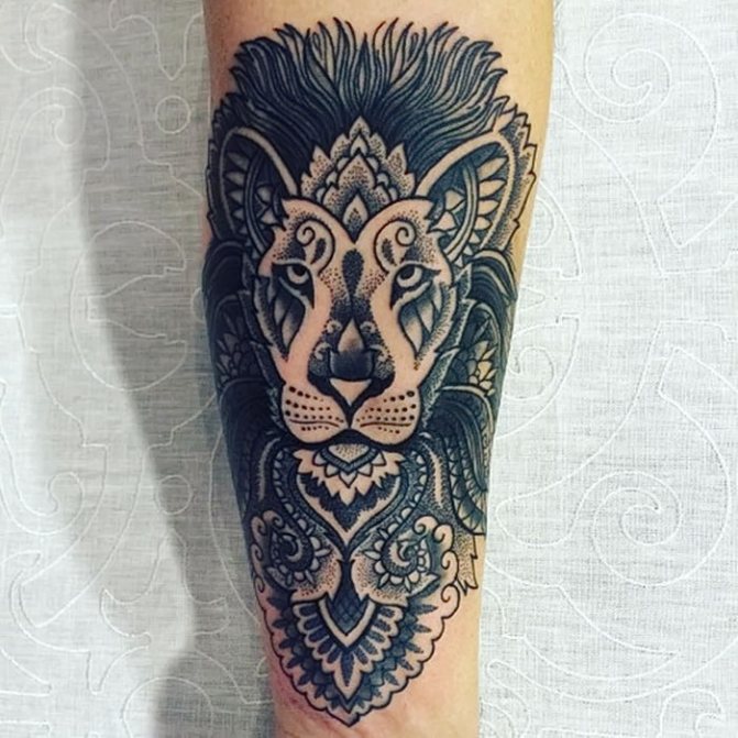 Juodai išdirbta liūto tatuiruotė su ornamentais ant dilbio