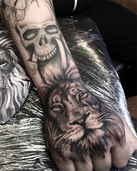 Tetoválás egy oroszlán a karon a férfiak számára