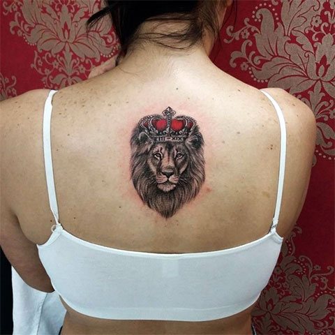 Tatuaggio leone con una corona sulla schiena di una ragazza (foto)