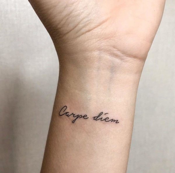 Tattoo grijp het moment in het Latijn (carpe diem). Schets, foto, betekenis