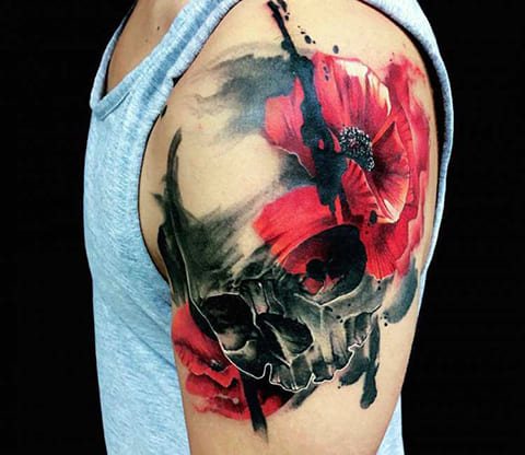 Tattoo van klaproos en doodskop op een mannelijke schouder