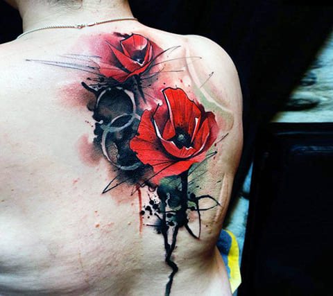 Tattoo van een klaproos op haar schouderblad
