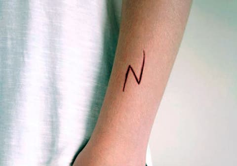 Bliksem tattoo op de arm van een meisje