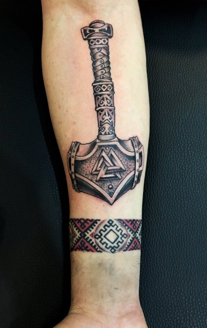 纹身雷神之锤。胳膊、手、背、肩、腿、照片上的标志
