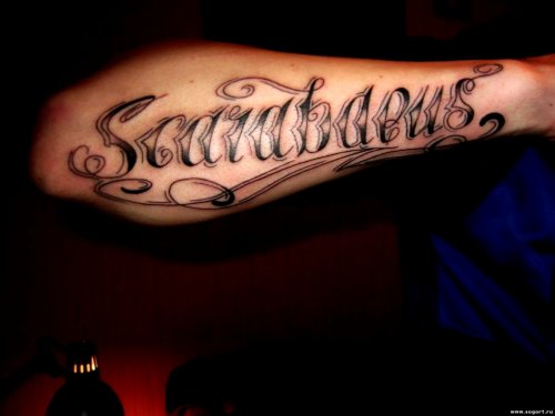 latijnse tatoeages op de arm van een man