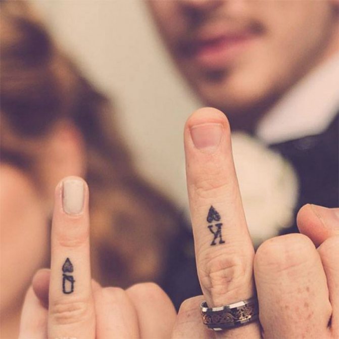 Tatuagem nos dedos como cartão de rei e rainha