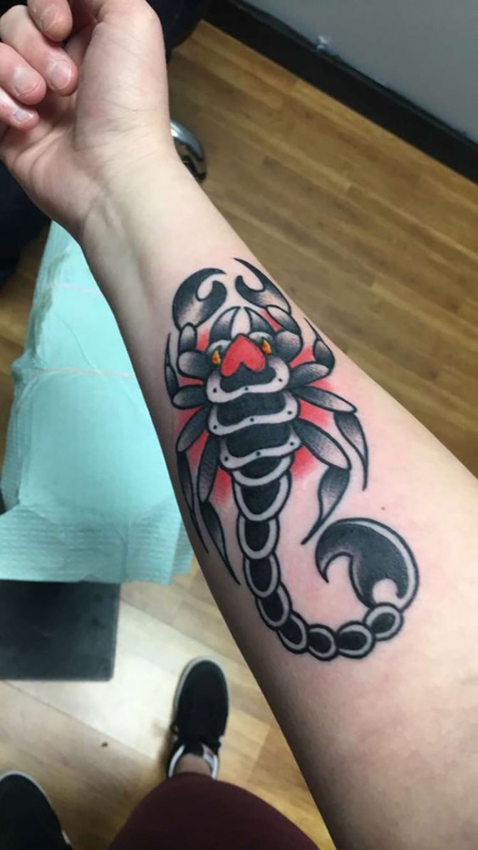 Skorpionin tatuointi punaisella ympyrällä käsivarteen