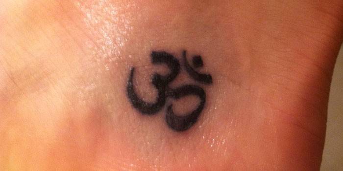 Tetoválás a lányok bokáján - Om szimbólum