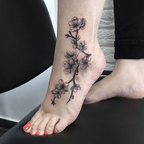 Tatuaggio sul piede della ragazza. Schizzi, foto