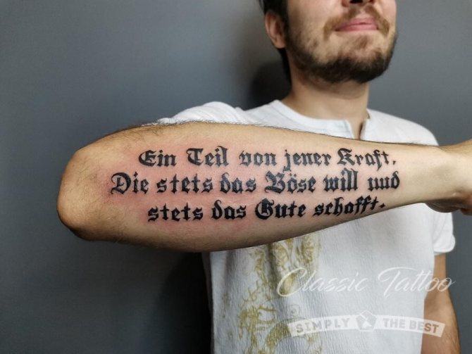 Goottilaistyylinen tatuointi miehen kyynärvarteen