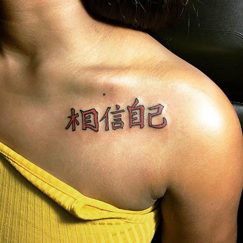 女孩锁骨上的拉丁文翻译的纹身铭文。照片、草图