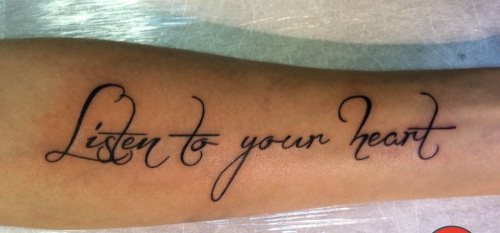 Tatuaż z napisami na ramieniu dziewczynki. Zdjęcie, szkice w języku łacińskim z tłumaczeniem, znaczenie