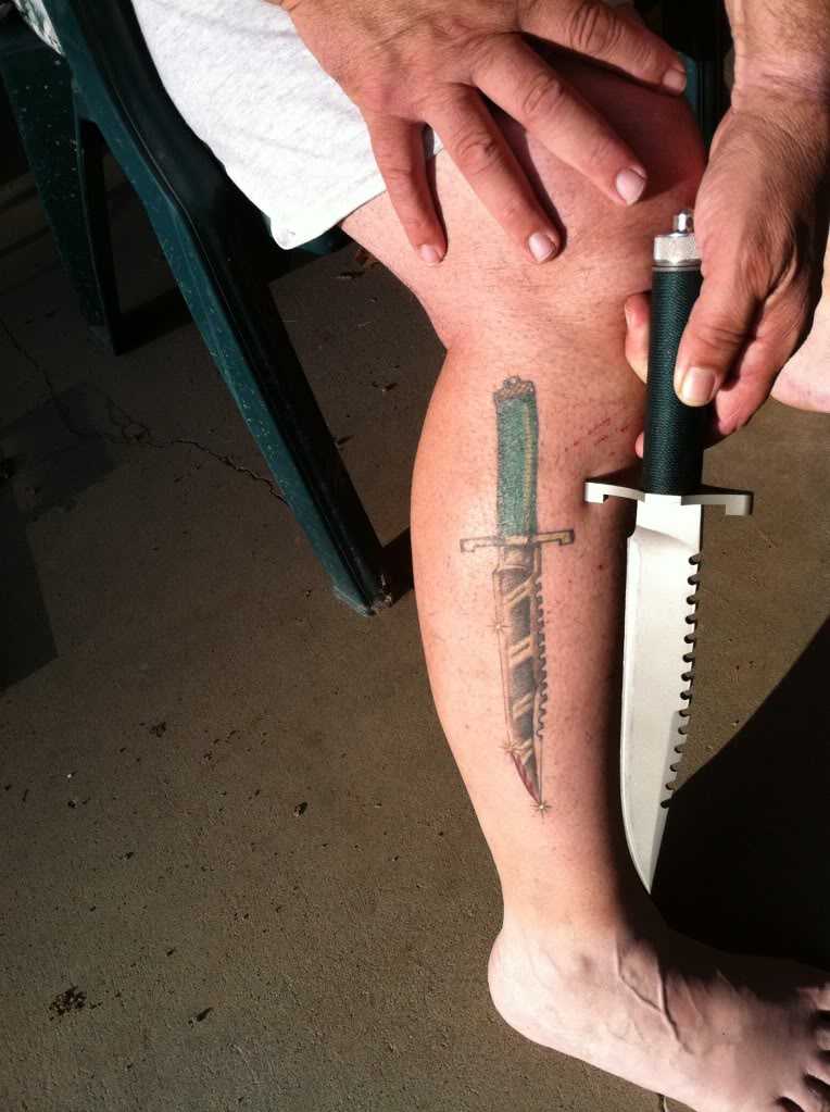 Tatuaggio del coltello sulla sua gamba