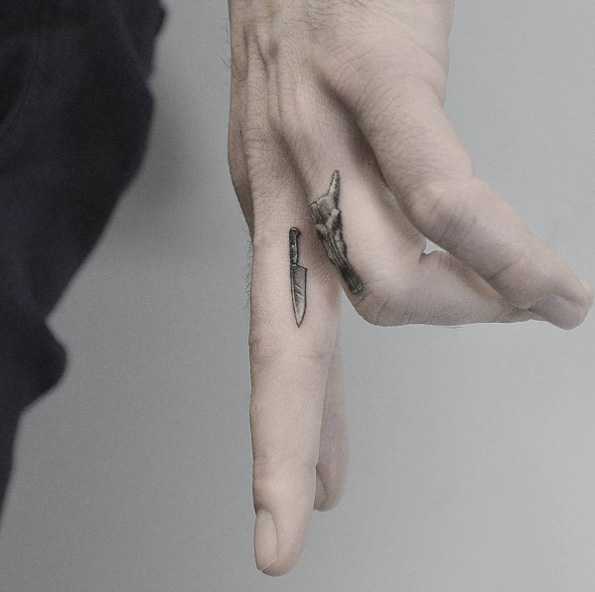 Tatuagem de uma faca no seu dedo