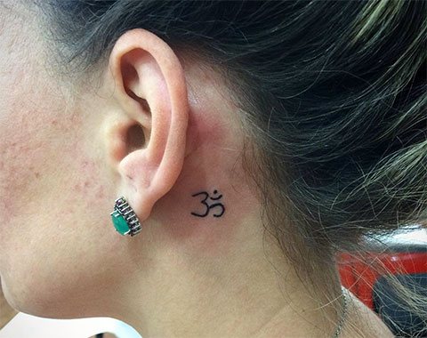 Τατουάζ Eom πίσω από το αυτί ενός κοριτσιού