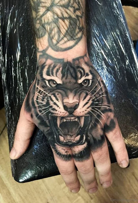 Tatuointi tiikeri virnistää kädessä